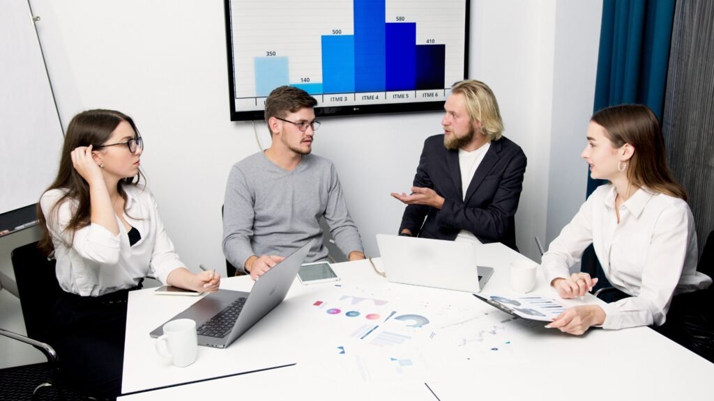 Business professionals discussing data-driven decisions with charts and laptops